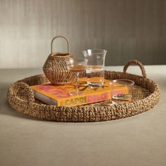 a wicker tray with two glasses and a book