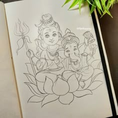 an open book with a drawing of lord ganesha on it and a potted plant in the background