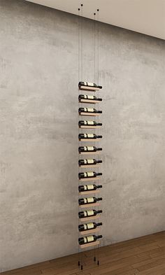 a tall wine rack with bottles hanging from it's sides in an empty room