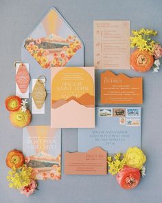 the wedding stationery is laid out on top of each other, including an orange and yellow flower