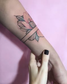 a woman's arm with a flower tattoo on the left side of her arm