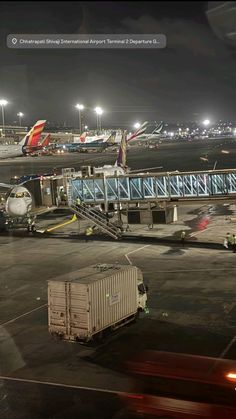 an airport tarmac at night with airplanes parked