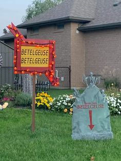 a sign in front of a house that has been decorated with lights and is pointing to the left