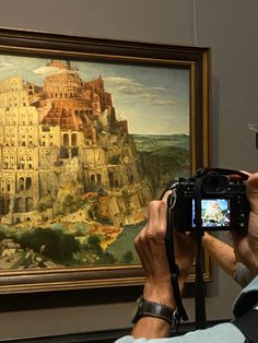 a man taking a photo of a painting with a camera in front of his face