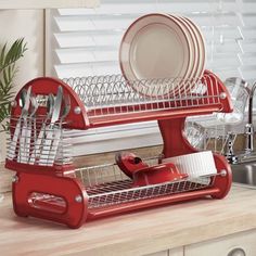 a red dish rack with plates and utensils in it on a kitchen counter