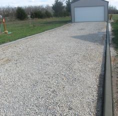 a gravel driveway with a garage in the background