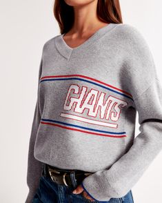 Elevate your game day attire with the Abercrombie & Fitch Women's New York Giants Luxeloft V-Neck Sweater. This chic gray sweater is a perfect blend of comfort and team spirit, crafted from a luxurious mix of viscose, polyester, and nylon.

- **Size**: XS
- **Color**: Gray
- **Material**: Viscose, Polyester, Nylon
- **Gender**: Female
- **Age Group**: Adult
- **Features**: New York Giants logo detail, V-neckline, ribbed cuffs, hem, and neckline

Ideal for pairing with denim or leggings, this swe New York Giants Logo, Giants Logo, Denim Bottoms, Women's Graphic Tees, Gray Sweater, New York Giants, Casual Elegance, Graphic Tees Women, Cozy Sweaters