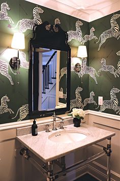 a bathroom with zebra wallpaper and a mirror above the sink, lights on either side