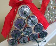 an ornament made out of soda cans with red ribbon