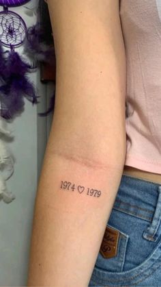 a woman's arm with a tattoo that reads, 1974 - 1970 on it