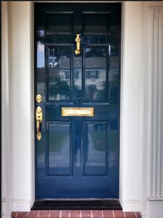 a blue front door with gold handles on it