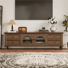 a living room with a large flat screen tv mounted on the wall above it's entertainment center