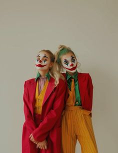 two people dressed in clown makeup standing next to each other