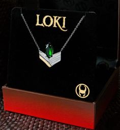 a box with a necklace in it that says loki