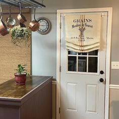 a kitchen with pots and pans hanging on the wall next to an open door