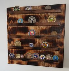 a wooden wall hanging with many different badges on it