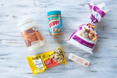 some snacks are sitting on a table next to each other, including yogurt and cookies