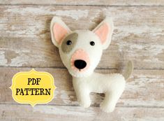 a stuffed dog is sitting on a wooden surface with the words pde pattern below it