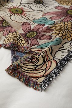 two rugs with flowers on them sitting on top of a white tablecloth,