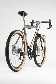 a silver and gold bike with black spokes on it's front wheel, against a white background