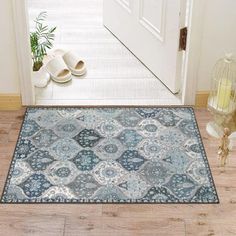 a door mat with an ornate design on the floor next to a pair of shoes