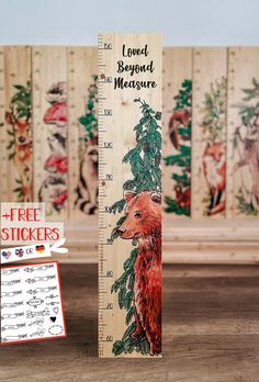 a wooden ruler with an image of a bear on it and the words loved beyond measure