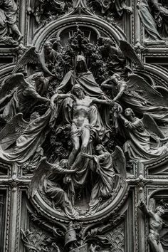 an ornate sculpture on the side of a church door with angels and other figures around it