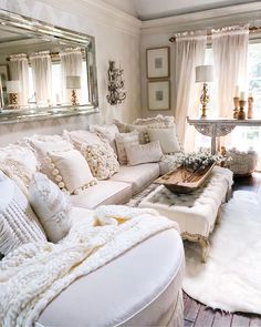 a living room filled with lots of white furniture