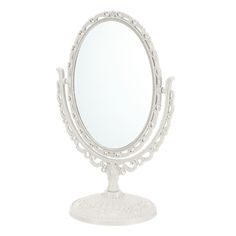 a white vanity mirror sitting on top of a wooden stand with an ornate design around it