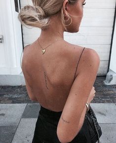 a woman with her back turned to the side wearing gold hoop earrings and a black dress