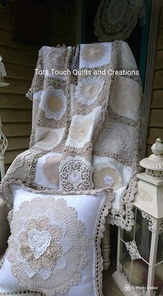 two white pillows sitting next to each other on top of a bed covered in crochet