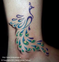 a peacock tattoo on the ankle with blue, green and yellow feathers painted on it