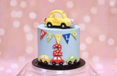 a birthday cake decorated with cars and bunting