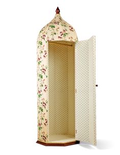 an open wardrobe with floral fabric and polka dots on the door, in front of a white background