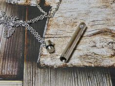 a metal object sitting on top of a wooden table next to a pen and chain