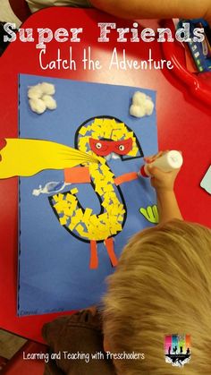 a young boy is drawing on a paper with the number 5 in front of him