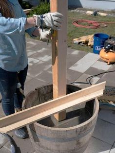 a woman is working on some wood in a barrel with other tools around the barrel