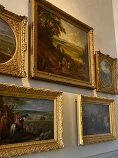 several paintings are hanging on the wall next to each other