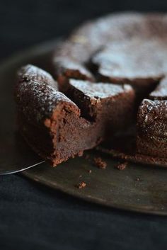 a chocolate cake is cut into pieces on a plate