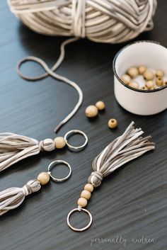 some beads are sitting on a table next to yarn and a bowl with something in it