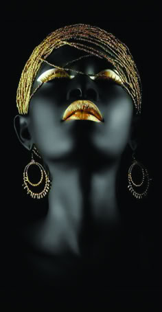 a woman's face with gold jewelry and earrings on her head, against a black background