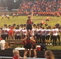 a group of people standing on top of a football field