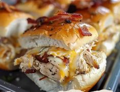 several sandwiches with meat, cheese and bacon on them