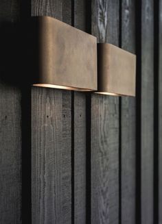 two lights on the side of a wooden wall