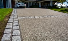 a car parked in front of a house on a driveway with cobblestone pavers