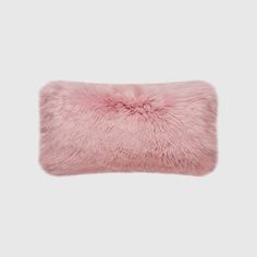 a pink furry pillow on a white background