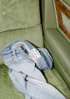 a pair of jeans sitting on top of a green chair