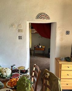 a dining room table filled with plates and bowls of food next to an open doorway