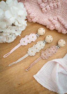 four pieces of crocheted hair accessories laid out on top of a wooden table