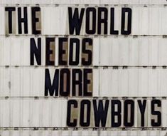 there is a sign that says the world needs more cowboys on it and has words written in black